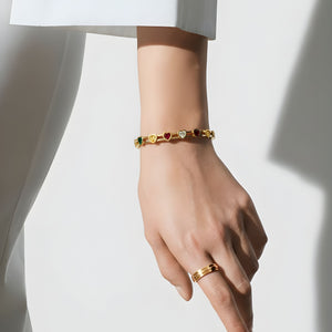Elegant gold women's bracelet with multicolor heart-shaped gemstones, featuring a stylish bangle design by Sajna Sawarnaa.