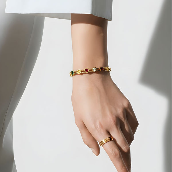 Elegant gold women's bracelet with multicolor heart-shaped gemstones, featuring a stylish bangle design by Sajna Sawarnaa.