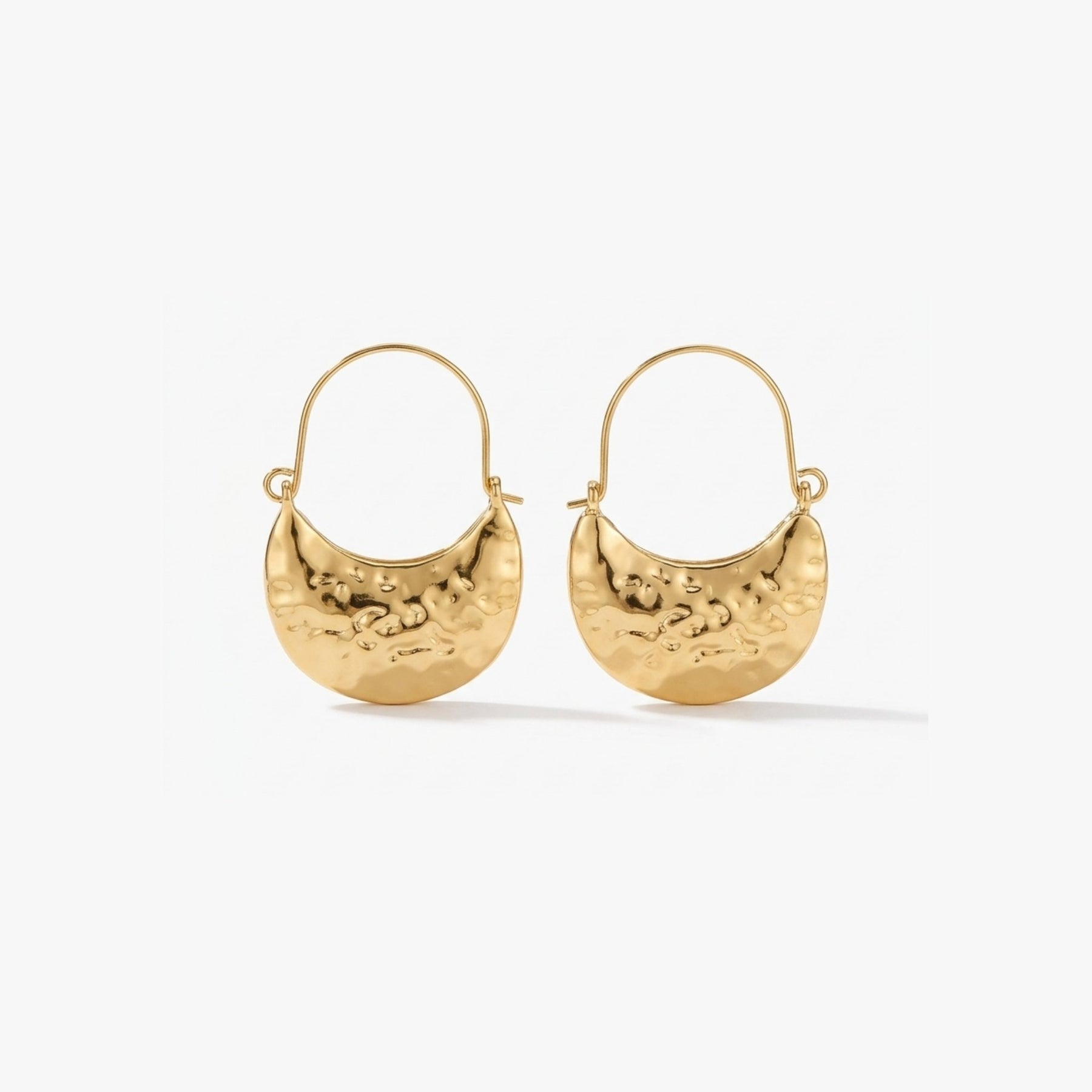 Woman wearing Luna Clutch hammered gold hoop earrings with luxury pouch-inspired Korean statement design