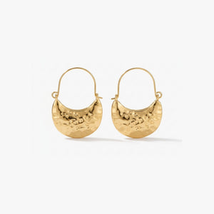 Woman wearing Luna Clutch hammered gold hoop earrings with luxury pouch-inspired Korean statement design