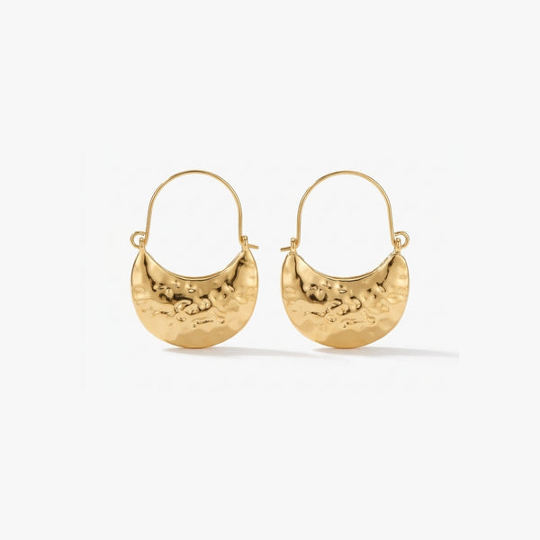 Woman wearing Luna Clutch hammered gold hoop earrings with luxury pouch-inspired Korean statement design