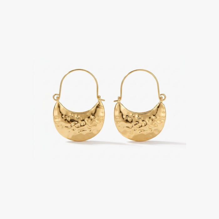 Woman wearing Luna Clutch hammered gold hoop earrings with luxury pouch-inspired Korean statement design