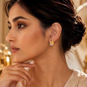 Woman wearing rainbow crystal gold huggie earrings with colorful prism stones and modern Korean luxury design