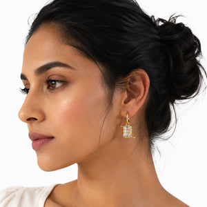 Woman wearing crystal wrapped gold hoop earrings with emerald-cut stones and modern Korean luxury design