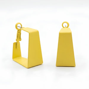 Woman wearing lime yellow geometric statement earrings with modern hollow trapeze design and trendy Korean fashion aesthetic
