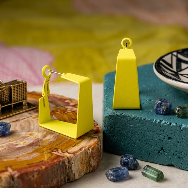 Woman wearing lime yellow geometric statement earrings with modern hollow trapeze design and trendy Korean fashion aesthetic
