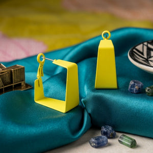 Woman wearing lime yellow geometric statement earrings with modern hollow trapeze design and trendy Korean fashion aesthetic
