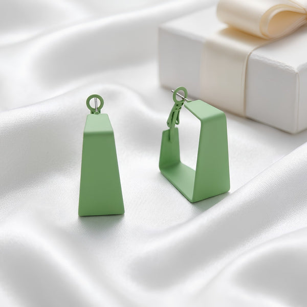 Woman wearing mint green geometric statement earrings with modern hollow trapeze design and trendy Korean fashion aesthetic