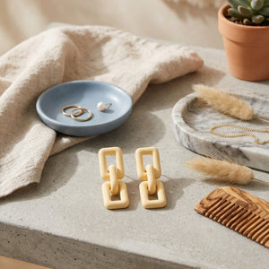 Woman wearing ivory geometric link statement earrings with modern matte finish and Korean-inspired minimal luxury design