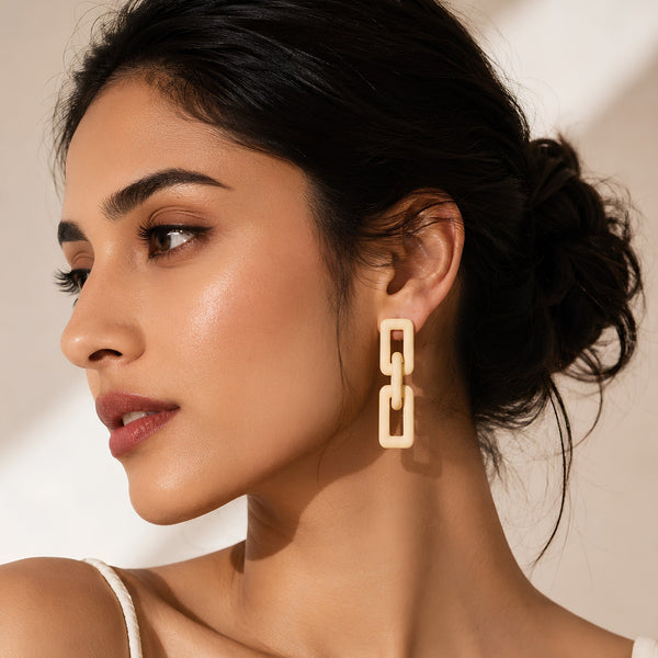 Woman wearing ivory geometric link statement earrings with modern matte finish and Korean-inspired minimal luxury design