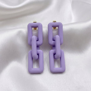 Woman wearing lavender pastel geometric chain-link statement earrings with Korean-inspired modern minimal design