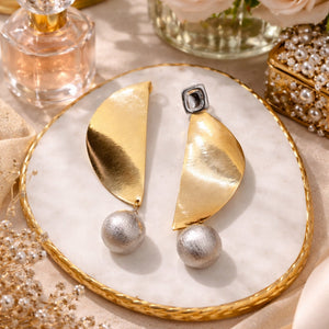 Luxury gold abstract statement earrings with textured silver pearl drops worn by a woman in elegant modern styling