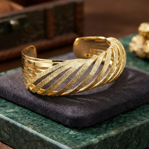 Elegant twisted gold cuff bracelet for women by Sajna Sawarnaa, featuring textured luxury design and anti-tarnish finish.