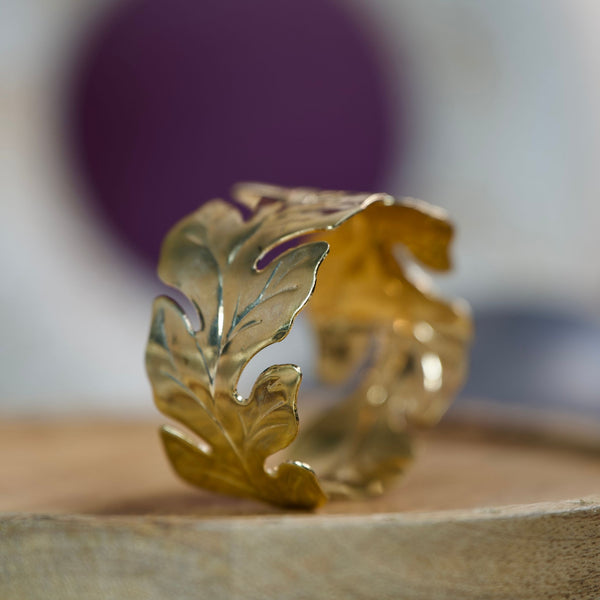 Gold women's bracelet with a leaf pattern and open cuff design, featuring nature-inspired jewelry by Sajna Sawarnaa.