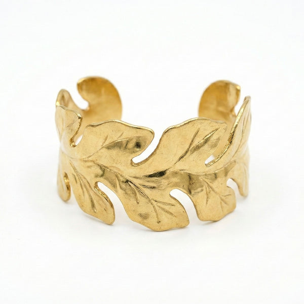 Women’s gold bracelet with leaf pattern and open cuff design, featuring nature-inspired jewelry by Sajna Sawarnaa.