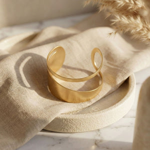 Elegant gold women's cuff bracelet with a double layer design, showcasing modern luxury jewelry by Sajna Sawarnaa.