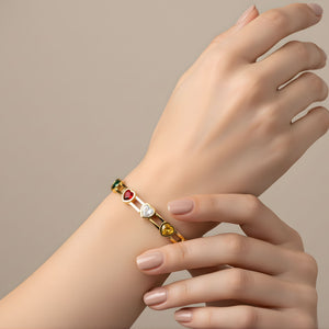 Elegant women's gold bracelet with multicolor heart-shaped gemstone charms, featuring a luxurious design by Sajna Sawarnaa.