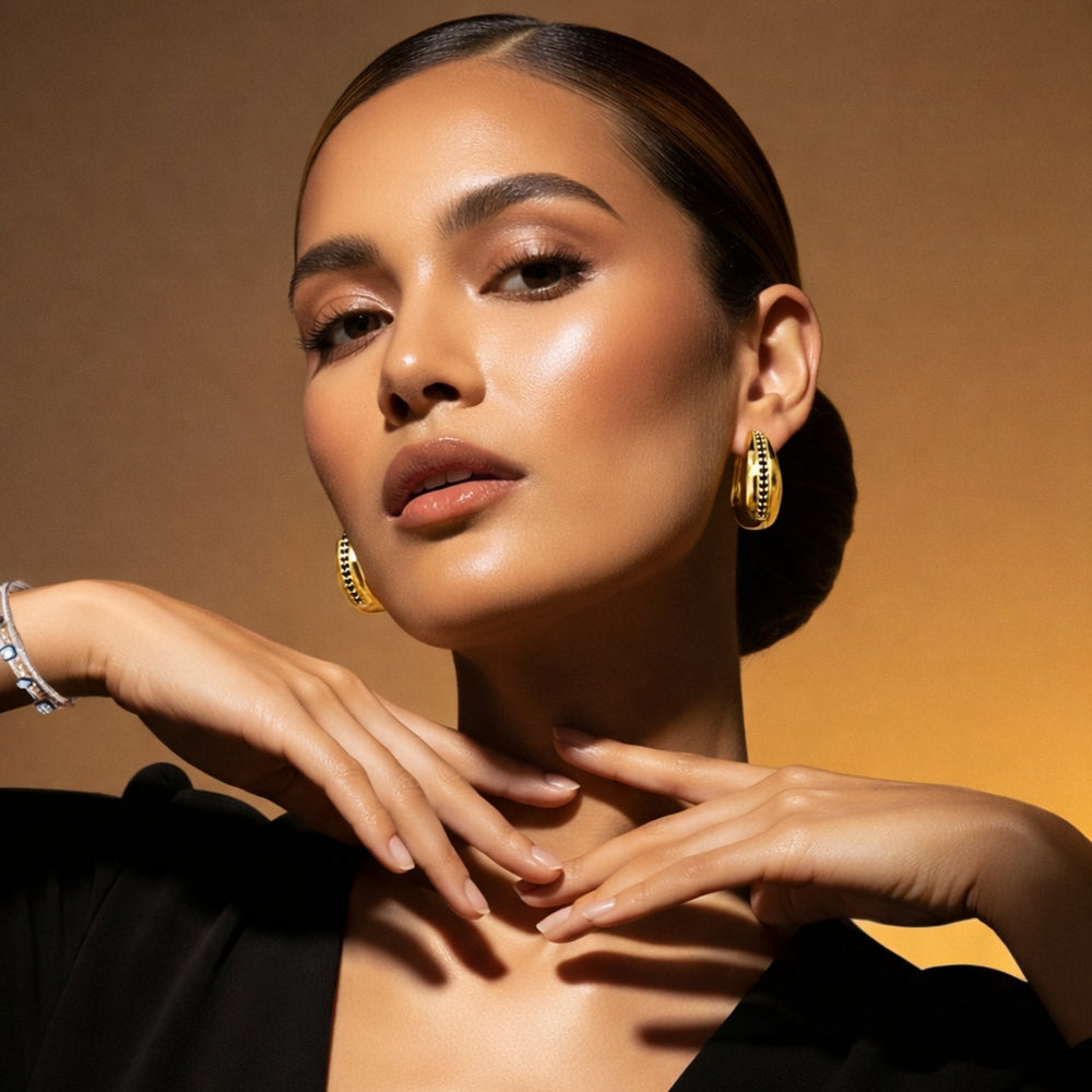 minimal luxury gold hoops close up black stones