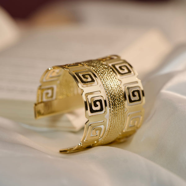 Royal gold statement cuff bracelet for women with Greek pattern, wide kada design, perfect for party wear jewelry by Sajna Sawarnaa.
