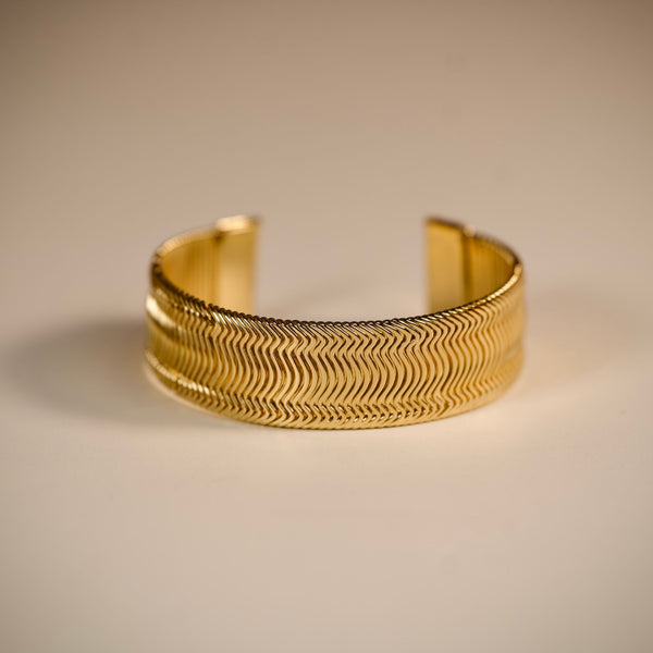 Women's gold wide cuff bracelet by Sajna Sawarnaa with textured design for elegant, everyday wear.