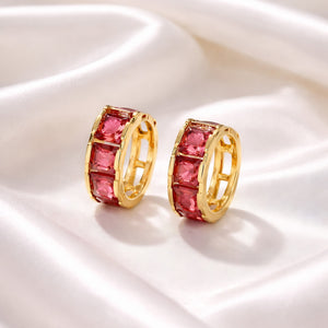 Premium pink gemstone hoop earrings displayed on soft satin fabric with luxury aesthetic styling
