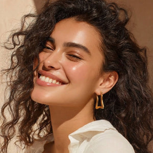 Model wearing golden geometric trapeze hoop earrings – on-ear lifestyle shot, everyday minimal style