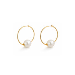 Gold hoop earrings with pearl beads on a white background