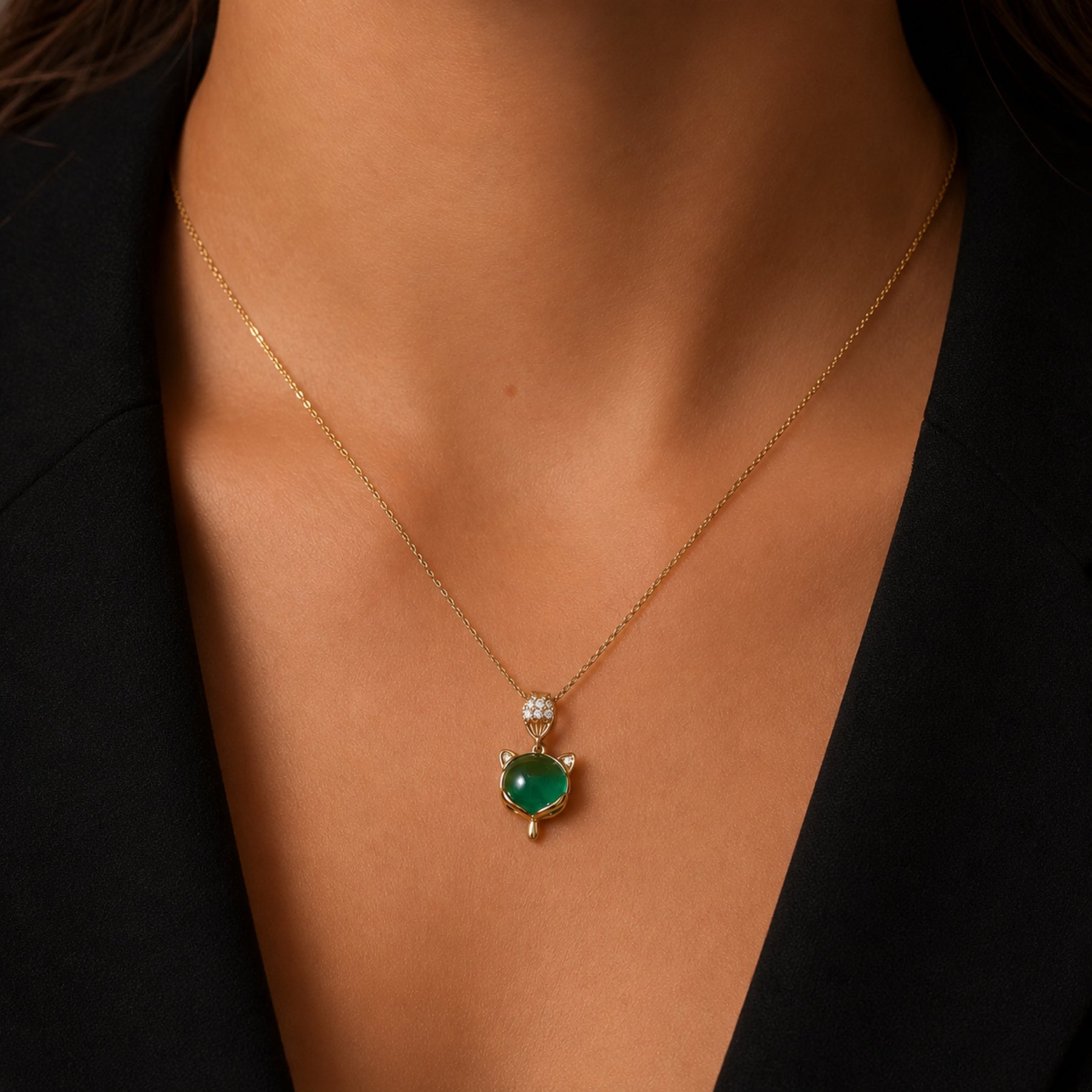 Woman wearing a gold-tone green cat charm necklace