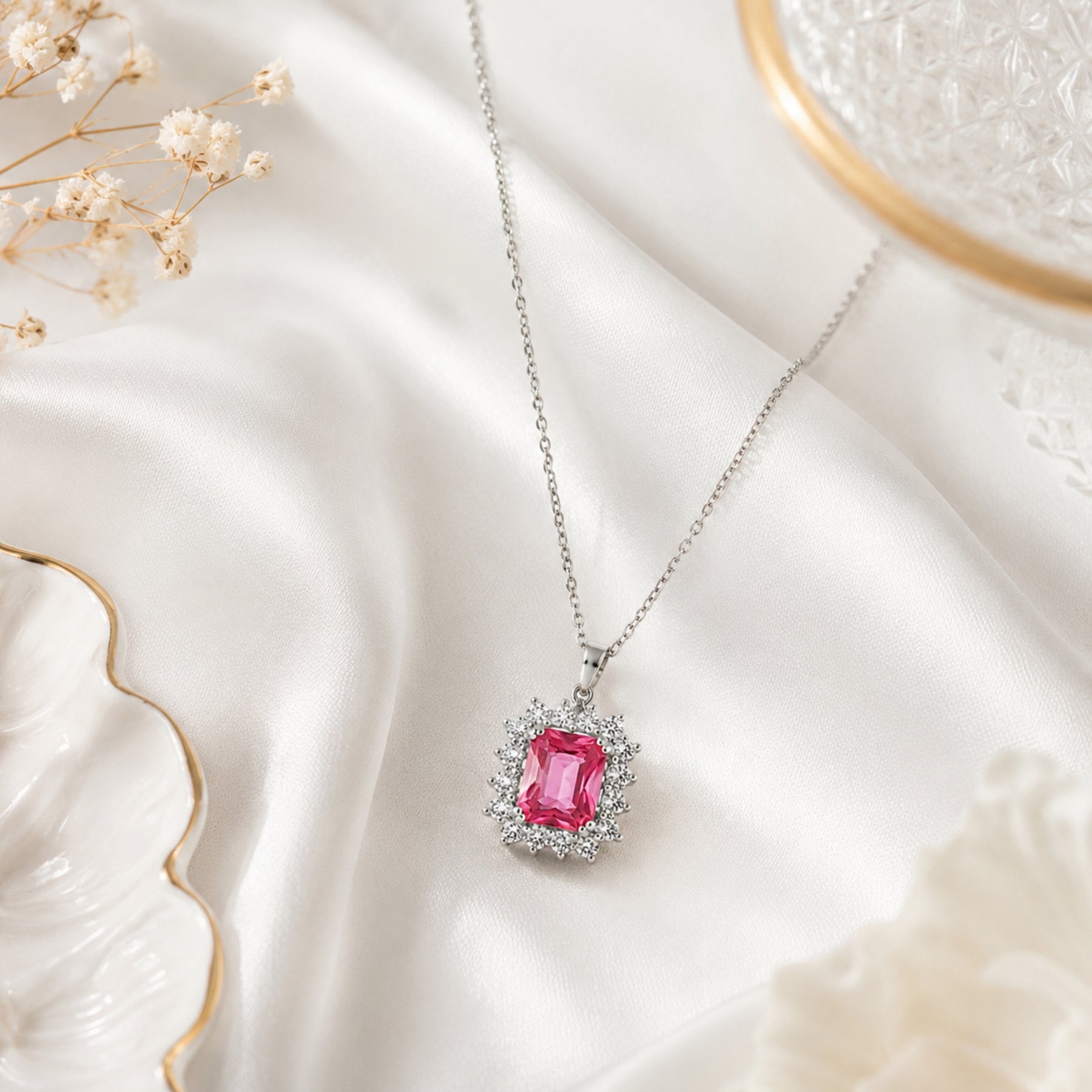 Silver-tone pink stone-accent pendant necklace styled on a white editorial background