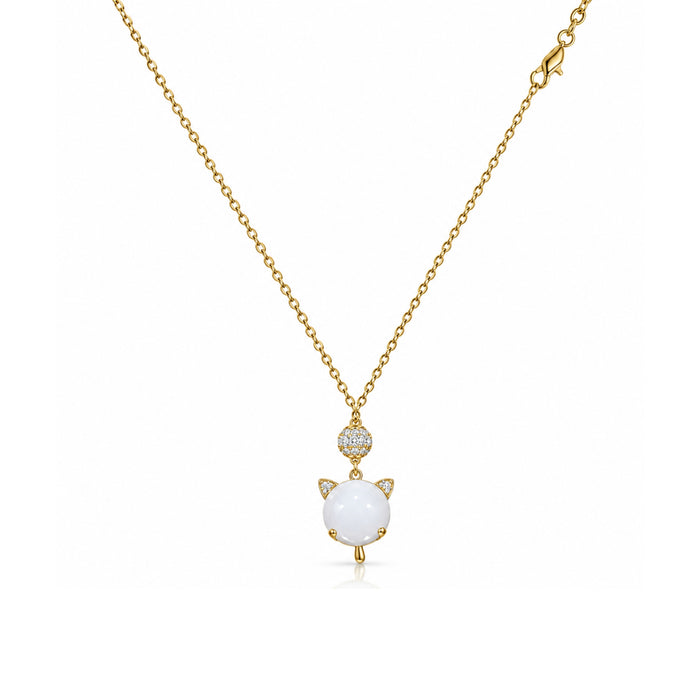 Gold-tone white cat charm pendant necklace with clear stone accents on a white background