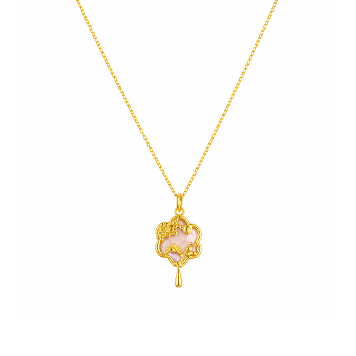 Gold-tone pink floral charm pendant necklace on a white background