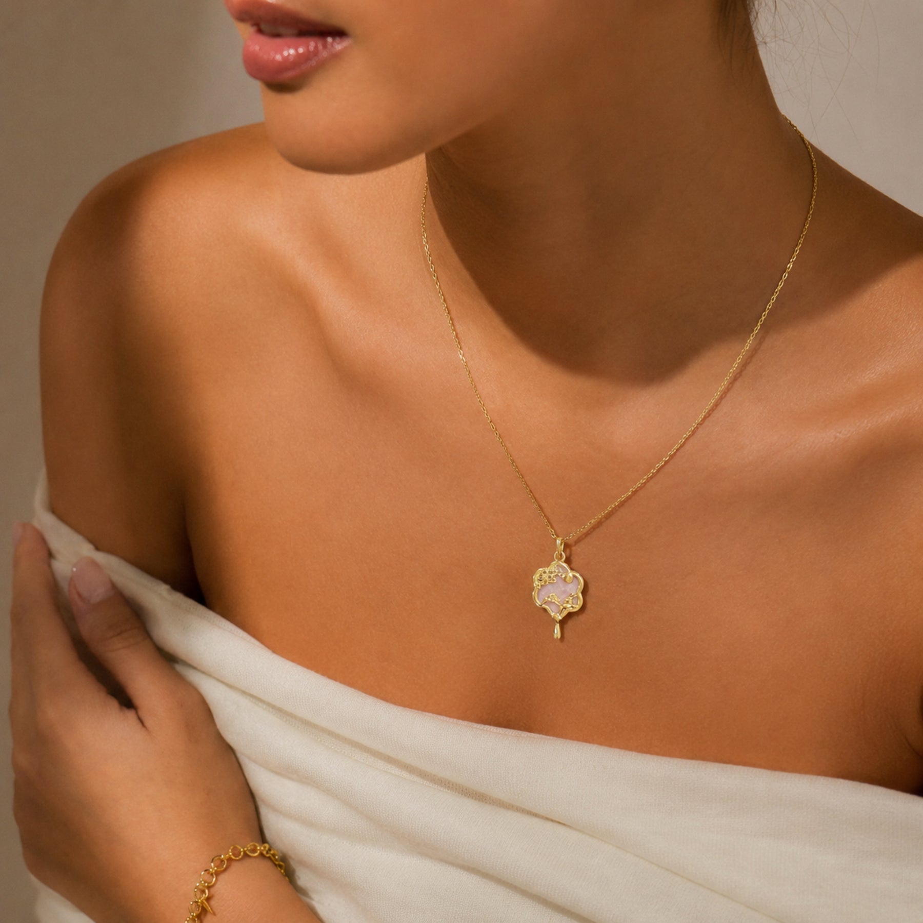 Woman wearing a gold-tone pink floral charm pendant necklace